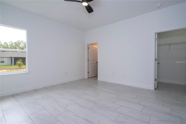 9825 N Swanee Ter, Dunnellon, FL 34433 - unfurnished bedroom with baseboards, a spacious closet, a ceiling fan, and a closet