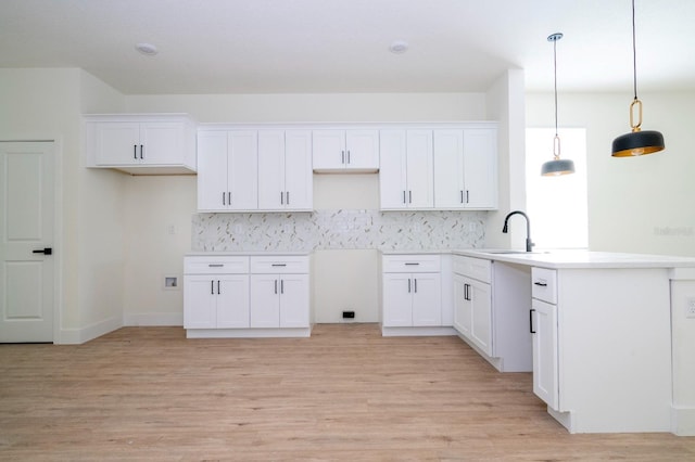 25 W 7th St, Apopka, FL 32703 - kitchen featuring decorative backsplash, white cabinets, and light wood-style floors