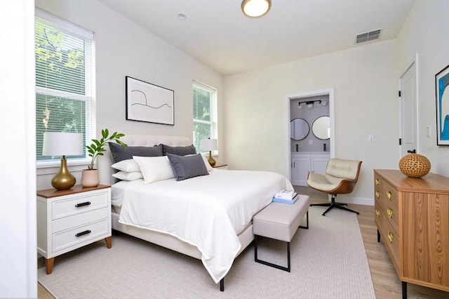 25 W 7th St, Apopka, FL 32703 - bedroom with light wood-style flooring, baseboards, and ensuite bathroom