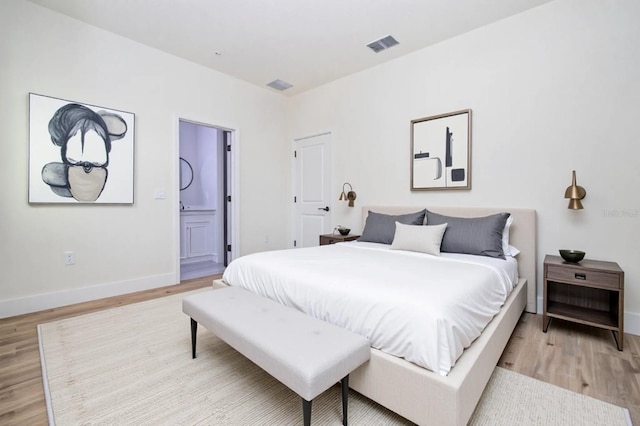 25 W 7th St, Apopka, FL 32703 - bedroom with light wood-style floors, baseboards, and ensuite bathroom
