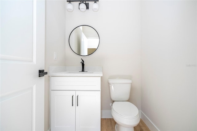 25 W 7th St, Apopka, FL 32703 - half bathroom featuring vanity, toilet, wood finished floors, and baseboards