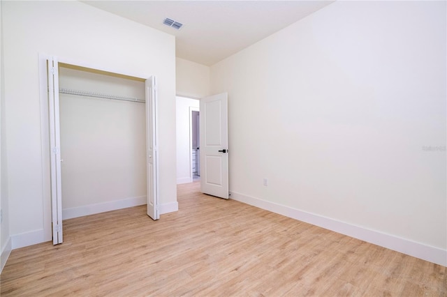 25 W 7th St, Apopka, FL 32703 - unfurnished bedroom with light wood-style floors, baseboards, and a closet