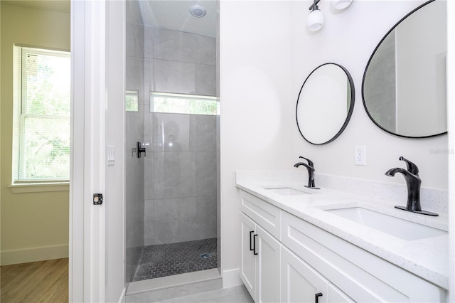 25 W 7th St, Apopka, FL 32703 - bathroom with tiled shower, double vanity, baseboards, and wood finished floors