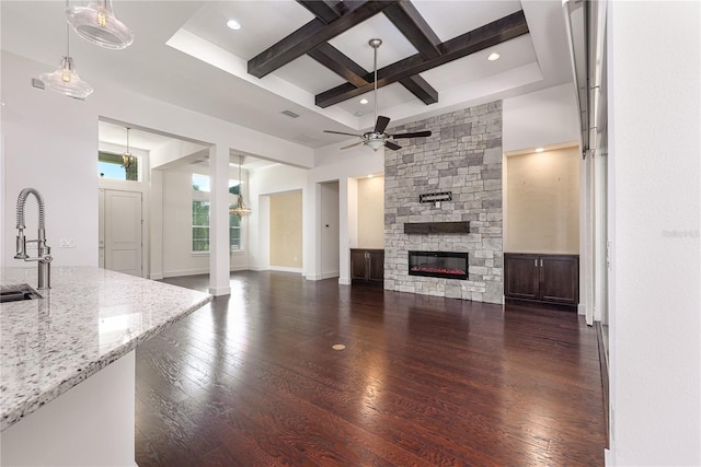 25859 Crossings Bluff Ln, Sorrento, FL 32776 - unfurnished living room with coffered ceiling, dark wood-style flooring, a ceiling fan, beamed ceiling, and a stone fireplace