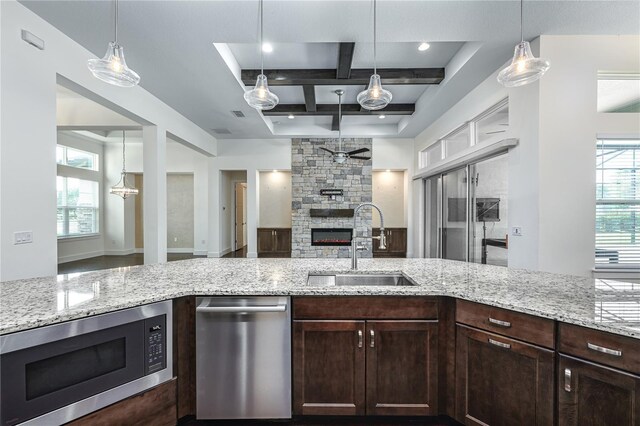 25859 Crossings Bluff Ln, Sorrento, FL 32776 - kitchen with stainless steel appliances, a sink, coffered ceiling, open floor plan, and light stone counters