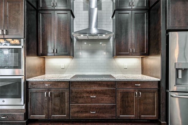 25859 Crossings Bluff Ln, Sorrento, FL 32776 - kitchen featuring appliances with stainless steel finishes, wall chimney exhaust hood, light stone counters, and decorative backsplash