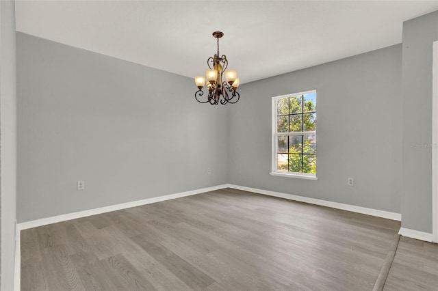 809 Deer Glen Ct, Fruitland Park, FL 34731 - unfurnished room featuring wood finished floors, a chandelier, and baseboards
