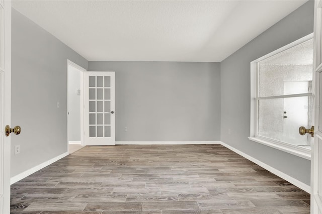 809 Deer Glen Ct, Fruitland Park, FL 34731 - empty room with french doors, wood finished floors, and baseboards