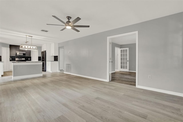 809 Deer Glen Ct, Fruitland Park, FL 34731 - unfurnished living room with a ceiling fan, light wood-style floors, and baseboards
