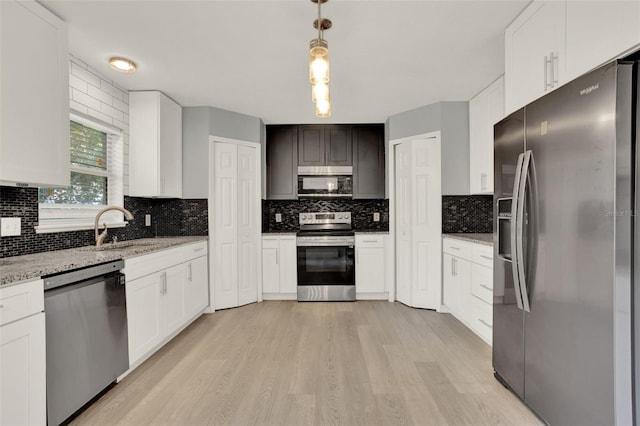 809 Deer Glen Ct, Fruitland Park, FL 34731 - kitchen with stainless steel appliances, a sink, light wood finished floors, and tasteful backsplash