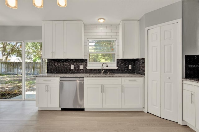 809 Deer Glen Ct, Fruitland Park, FL 34731 - kitchen featuring stainless steel dishwasher, a sink, decorative backsplash, and light stone counters