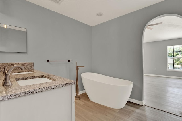 809 Deer Glen Ct, Fruitland Park, FL 34731 - full bathroom featuring wood finished floors, a freestanding tub, double vanity, and baseboards