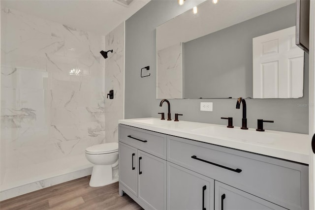 809 Deer Glen Ct, Fruitland Park, FL 34731 - full bath featuring toilet, double vanity, wood finished floors, and a marble finish shower
