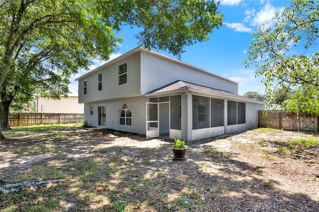 809 Deer Glen Ct, Fruitland Park, FL 34731 - back of property featuring a sunroom, a fenced backyard, stucco siding, and a shingled roof