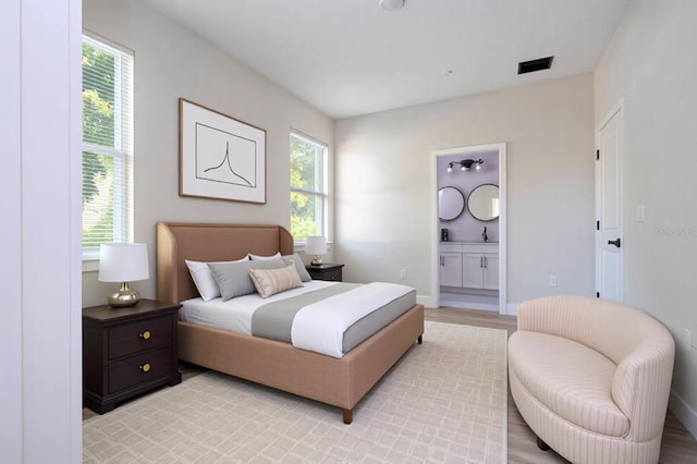 33 W 7th St, Apopka, FL 32703 - bedroom with multiple windows, ensuite bathroom, light wood-type flooring, and a sink