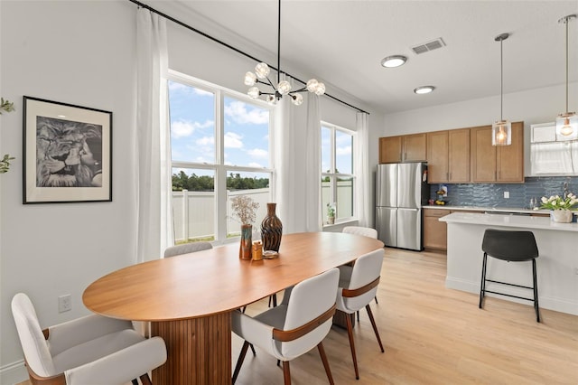701 Dennis Ave, Orlando, FL 32807 - dining space with light wood-style floors and a chandelier