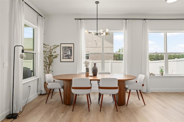 701 Dennis Ave, Orlando, FL 32807 - dining room featuring light wood-type flooring, a chandelier, and baseboards