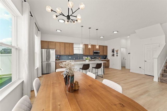 701 Dennis Ave, Orlando, FL 32807 - dining space with a chandelier, light wood finished floors, stairway, recessed lighting, and baseboards