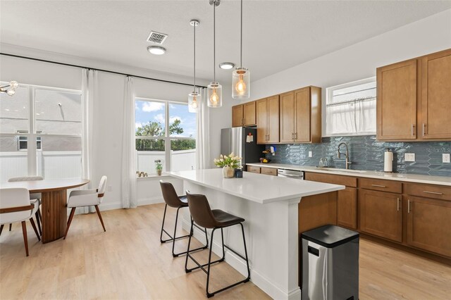 701 Dennis Ave, Orlando, FL 32807 - kitchen with a sink, a kitchen bar, appliances with stainless steel finishes, and brown cabinetry