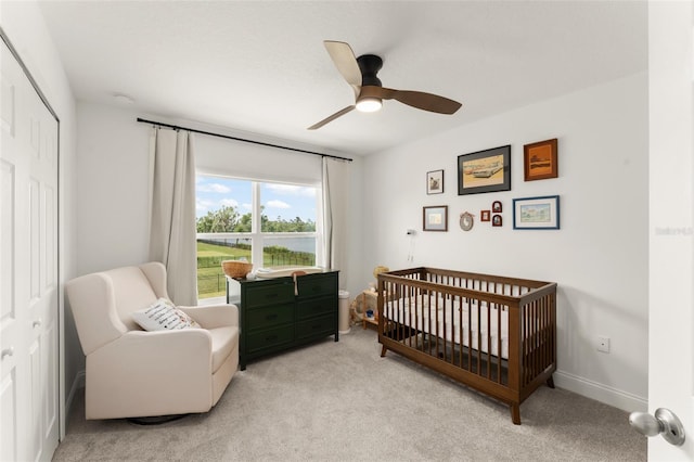 701 Dennis Ave, Orlando, FL 32807 - bedroom featuring light colored carpet, a crib, a ceiling fan, baseboards, and a closet