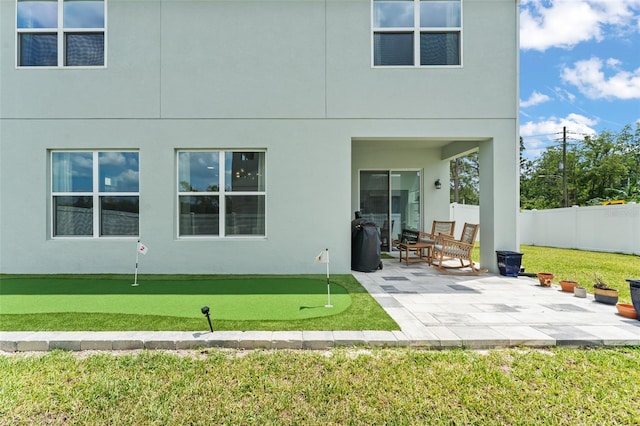 701 Dennis Ave, Orlando, FL 32807 - rear view of house with a putting green, a patio area, and stucco siding