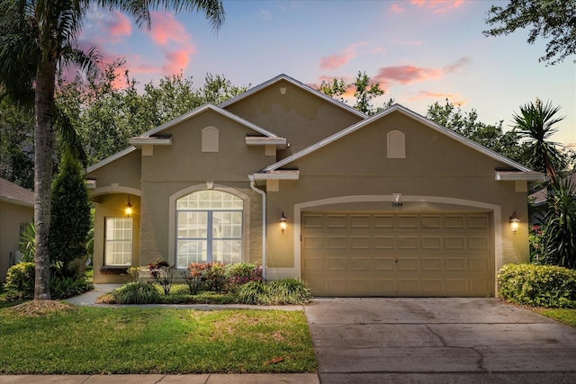 9644 Myrtle Creek Ln, Orlando, FL 32832 - view of front of house with stucco siding, an attached garage, driveway, and a yard