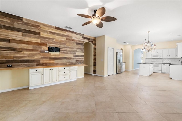 9644 Myrtle Creek Ln, Orlando, FL 32832 - unfurnished living room with arched walkways, wooden walls, a ceiling fan, a sink, and a chandelier