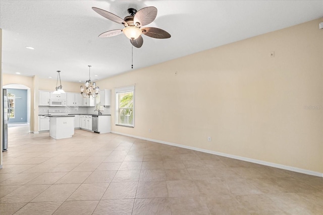 9644 Myrtle Creek Ln, Orlando, FL 32832 - unfurnished living room with a ceiling fan, a chandelier, arched walkways, a sink, and baseboards