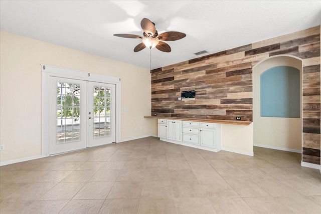9644 Myrtle Creek Ln, Orlando, FL 32832 - unfurnished living room featuring ceiling fan, french doors, wooden walls, arched walkways, and baseboards