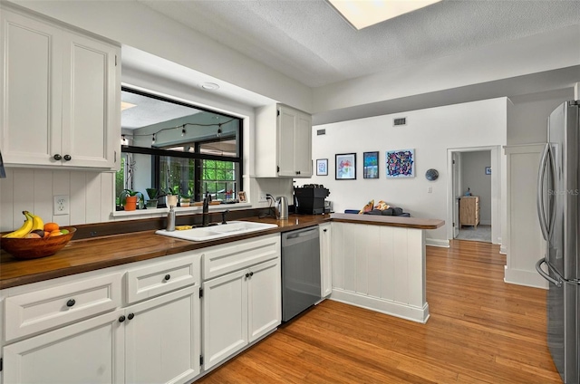 1202 Marshall Ct, Eustis, FL 32726 - kitchen with stainless steel appliances, a sink, light wood finished floors, white cabinets, and butcher block counters