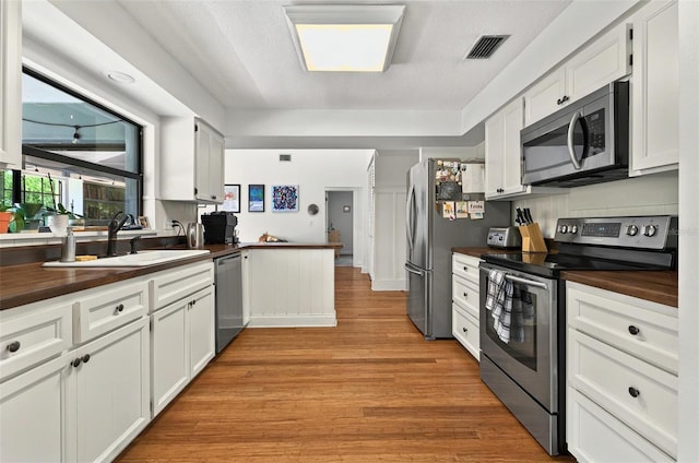 1202 Marshall Ct, Eustis, FL 32726 - kitchen with appliances with stainless steel finishes, butcher block countertops, a sink, and light wood finished floors