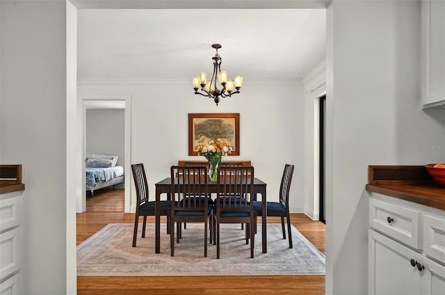 1202 Marshall Ct, Eustis, FL 32726 - dining area featuring a chandelier, light wood-style floors, and crown molding