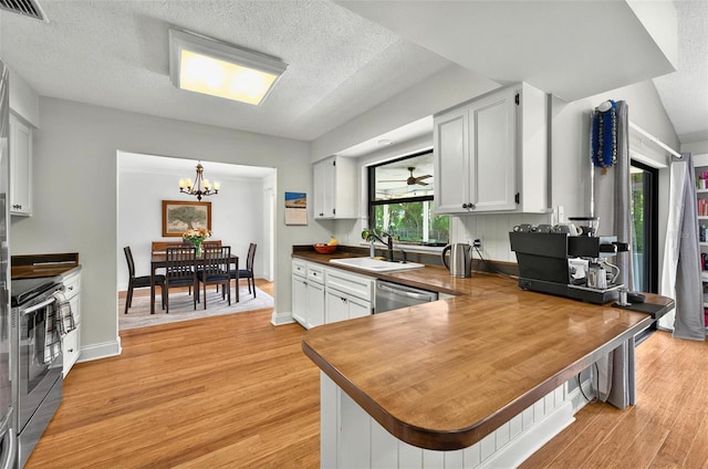 1202 Marshall Ct, Eustis, FL 32726 - kitchen with stainless steel appliances, a sink, a chandelier, light wood-type flooring, and a textured ceiling