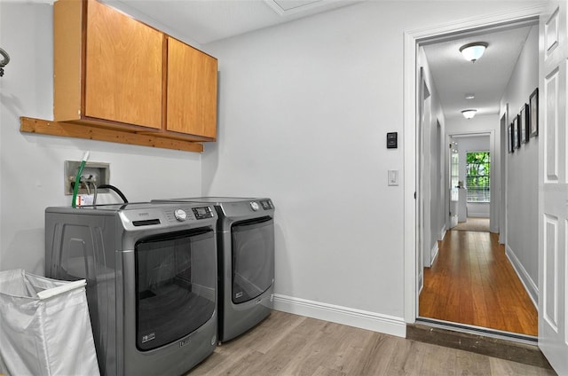 1202 Marshall Ct, Eustis, FL 32726 - washroom featuring cabinet space, light wood-style flooring, washer and clothes dryer, and baseboards