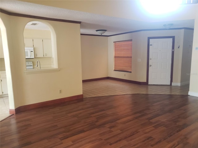 706 Lighthouse Ct, Altamonte Springs, FL 32714 - empty room with dark wood-style flooring, crown molding, a sink, baseboards, and arched walkways