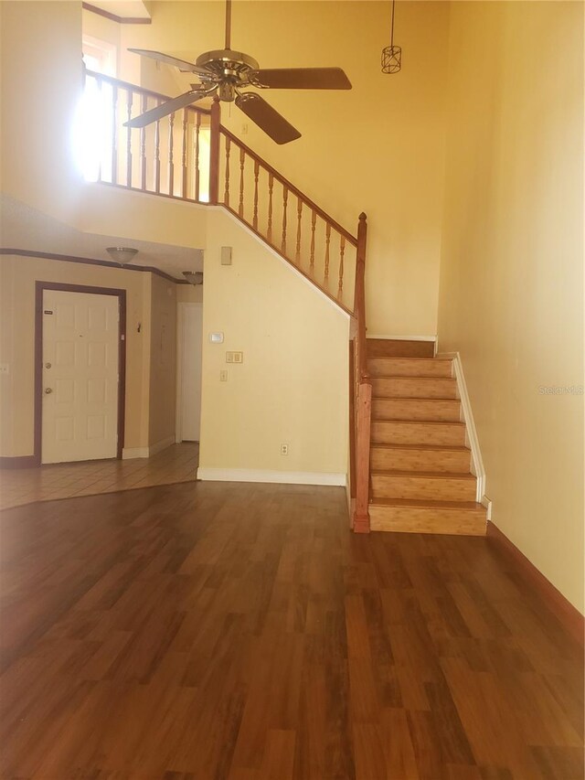 706 Lighthouse Ct, Altamonte Springs, FL 32714 - unfurnished living room featuring stairs, a ceiling fan, wood finished floors, baseboards, and a towering ceiling