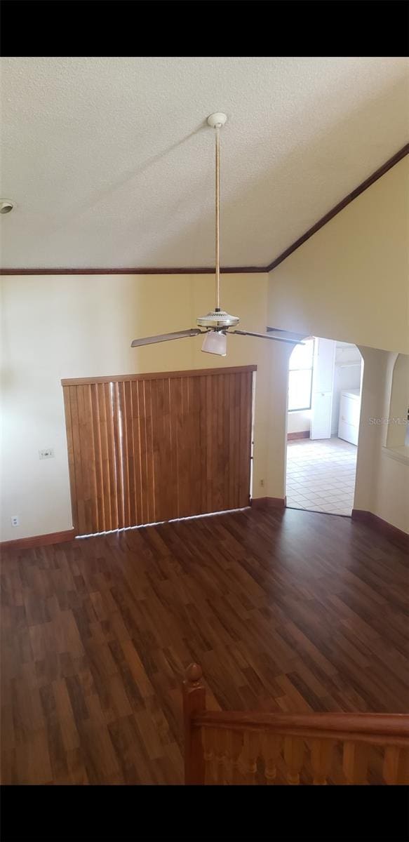 706 Lighthouse Ct, Altamonte Springs, FL 32714 - spare room with lofted ceiling, ceiling fan, dark wood-style floors, a textured ceiling, and arched walkways