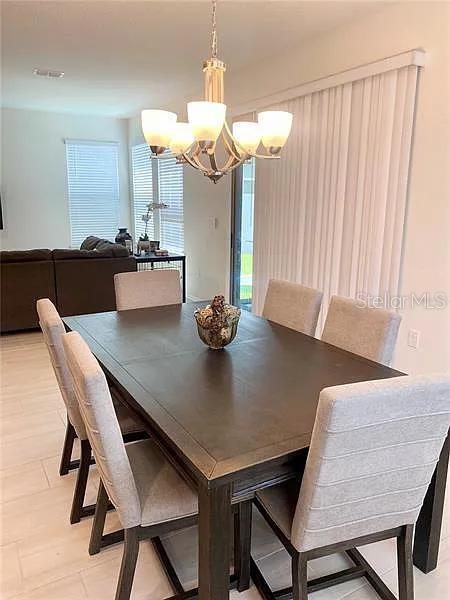 16391 Admirals Cove Ln, Winter Garden, FL 34787 - dining room with a chandelier and healthy amount of natural light
