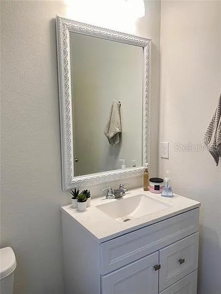 16391 Admirals Cove Ln, Winter Garden, FL 34787 - half bathroom with vanity, toilet, and a textured wall