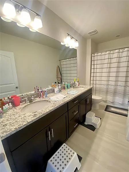 16391 Admirals Cove Ln, Winter Garden, FL 34787 - full bath with double vanity, toilet, and a shower with curtain