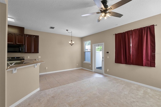 12335 Cruxbury Dr, Windermere, FL 34786 - kitchen with black microwave, range with electric cooktop, a kitchen bar, light colored carpet, and light tile patterned flooring