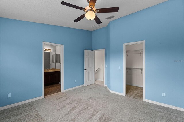 12335 Cruxbury Dr, Windermere, FL 34786 - unfurnished bedroom featuring a walk in closet, carpet flooring, a closet, a ceiling fan, and connected bathroom
