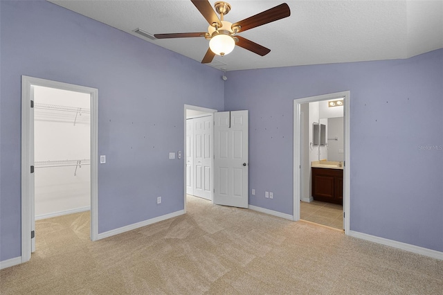12335 Cruxbury Dr, Windermere, FL 34786 - unfurnished bedroom with light colored carpet, vaulted ceiling, ensuite bathroom, ceiling fan, and a textured ceiling
