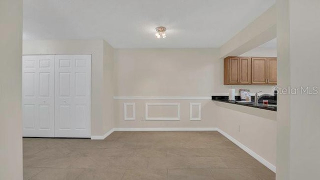 648 Kenwick Cir Unit 102, Casselberry, FL 32707 - kitchen with dark countertops, brown cabinetry, and baseboards