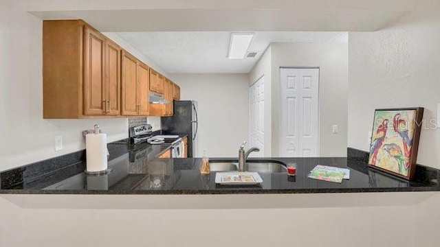 648 Kenwick Cir Unit 102, Casselberry, FL 32707 - kitchen featuring appliances with stainless steel finishes, a peninsula, brown cabinetry, extractor fan, and dark stone counters