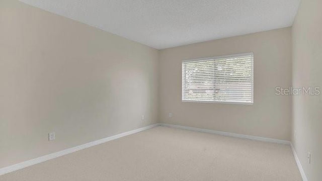 648 Kenwick Cir Unit 102, Casselberry, FL 32707 - carpeted empty room with a textured ceiling and baseboards
