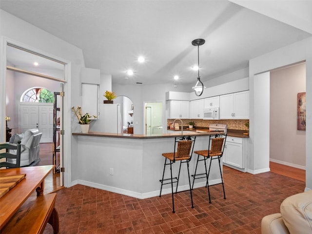 3518 Edlingham Ct, Belle Isle, FL 32812 - kitchen featuring white appliances, dark countertops, tasteful backsplash, white cabinets, and recessed lighting