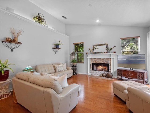 3518 Edlingham Ct, Belle Isle, FL 32812 - living area featuring lofted ceiling, plenty of natural light, a stone fireplace, and wood finished floors