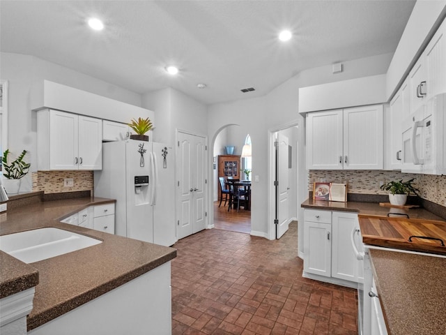 3518 Edlingham Ct, Belle Isle, FL 32812 - kitchen featuring dark countertops, white appliances, a sink, arched walkways, and recessed lighting