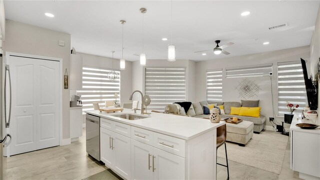 2627 Maitland Crossing Way Unit 101, Orlando, FL 32810 - kitchen with a sink, appliances with stainless steel finishes, white cabinets, a ceiling fan, and a center island with sink